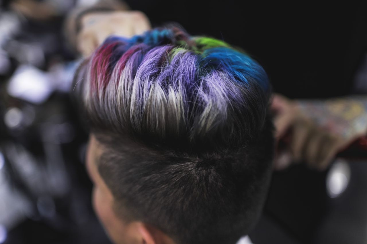 services-02 Close-up of a stylish multi-colored hairstyle showing vibrant rainbow hues, capturing modern hair artistry.