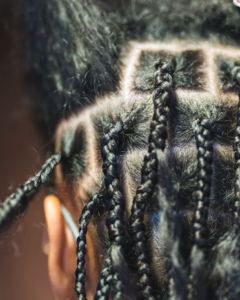 Close-up detail of finished ponytail braid style on Black hair showing braid texture, definition, and professional fluff near the ear
